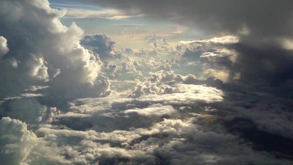 高空俯瞰的层层云海，阳光从云隙间透出